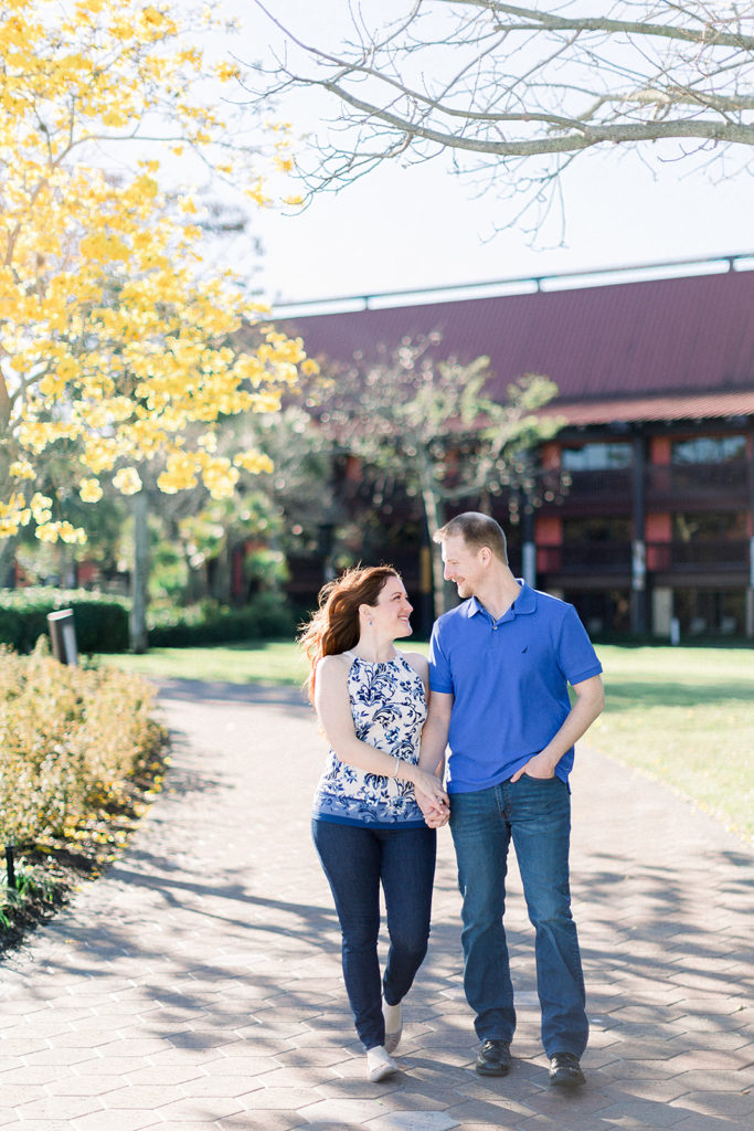 couple walk together at Disney's Polynesian resort for engagement session photos
