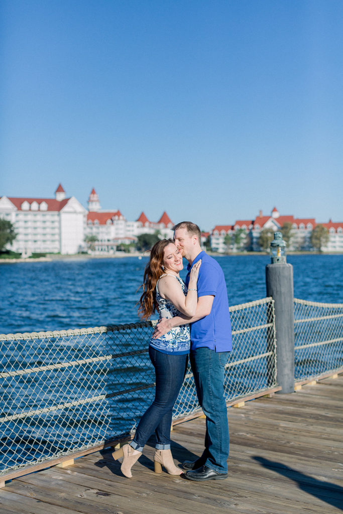 couple embrace at Disney's Polynesian resort dock for engagement session photos