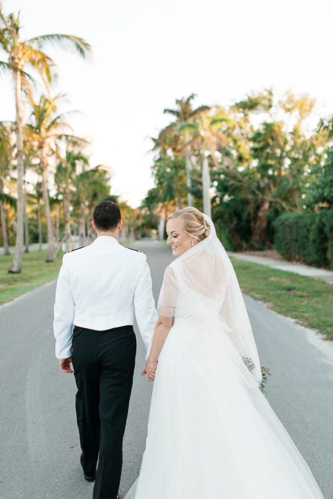 bride and groom stroll down street on gasparilla island at boca bay pass club wedding