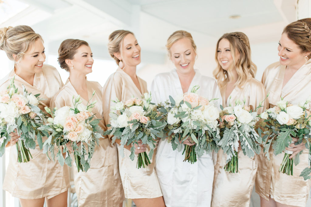 bridesmaids in silk robes with bouquets at boca bay pass club wedding
