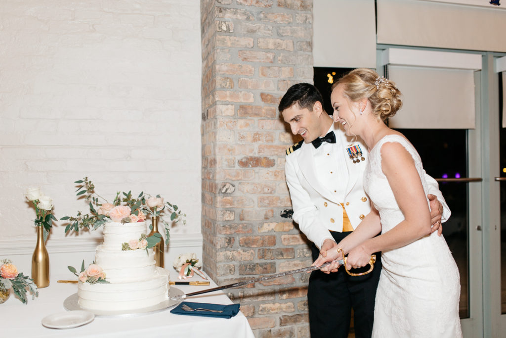 boca bay pass club reception bride and groom cut cake with navy sword