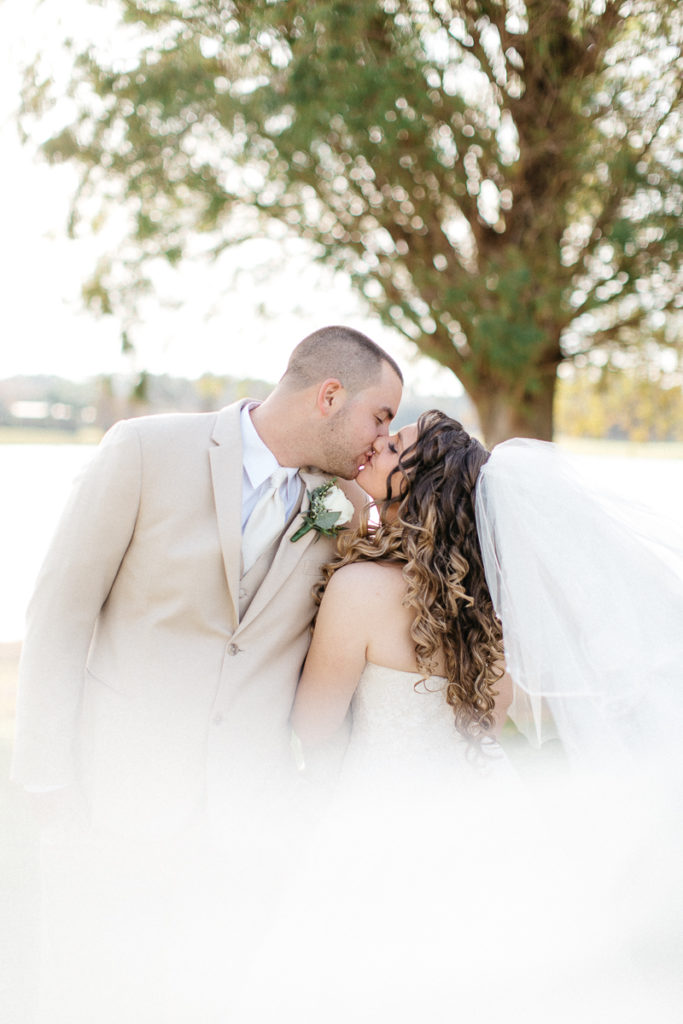 bride and groom first kiss at golden bear club wedding portraits
