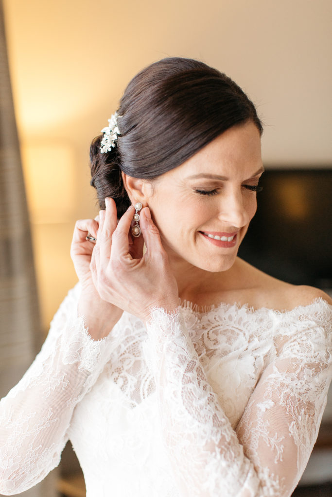 bride placing earrings on at the alfond inn