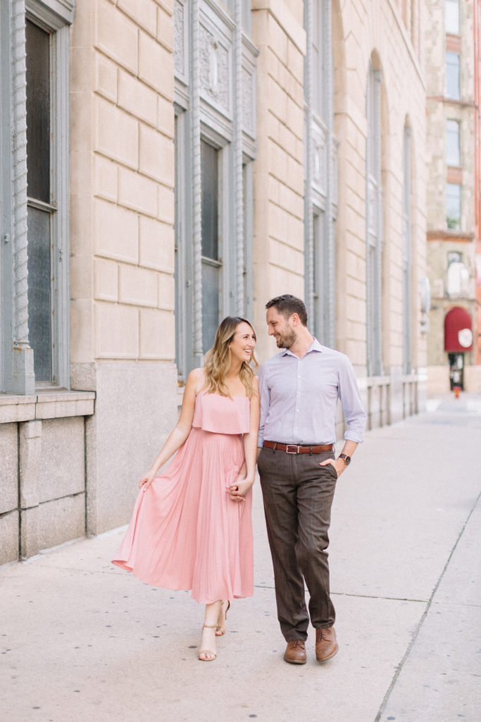 couple walking and looking at each on the sidewalk for Chicago, Illinois engagement session
