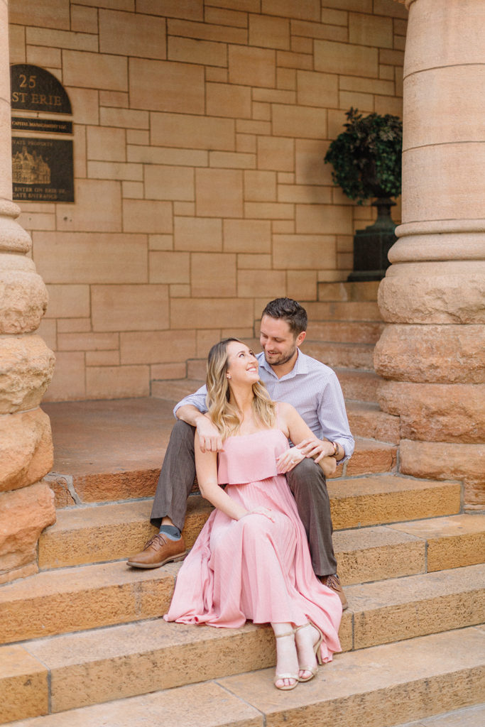 couple sitting on steps looking at each other for Chicago, Illinois engagement session