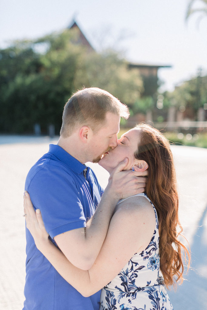 couple embrace at Disney's Polynesian resort beach for engagement session photos