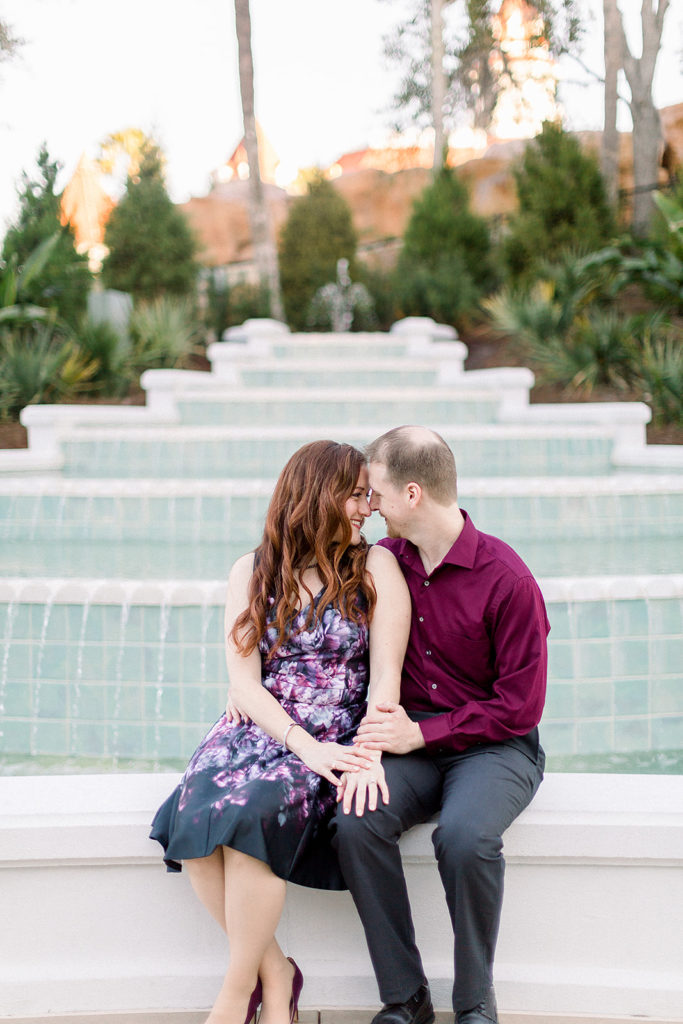couple embrace at Disney's grand Floridian resort for engagement session photos waterfall