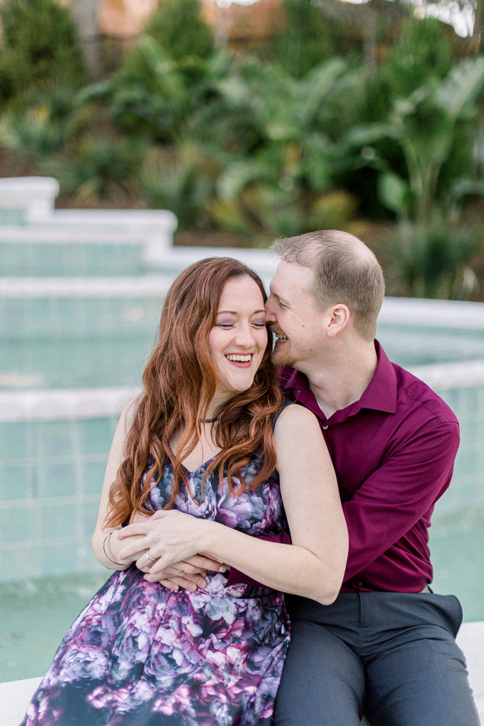 couple shares a laugh at Disney's grand Floridian resort for engagement session photos