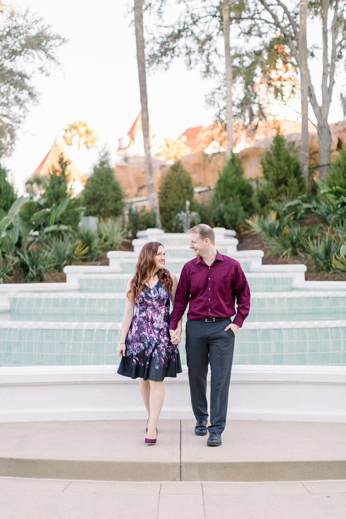 couple walking at Disney's grand Floridian resort for engagement session photos