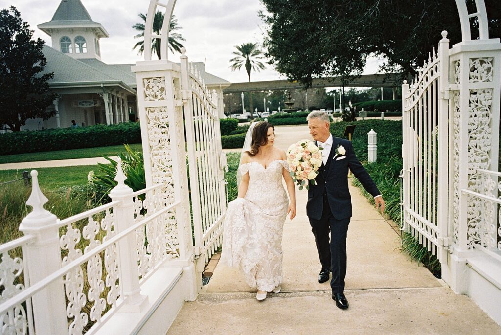 Bride walking with dad to her ceremony at Disney’s Grand Floridian captured by Walt Disney World wedding photographer Casie Marie Photography
