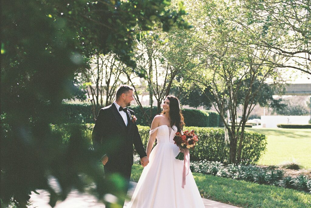 Bride and groom on their way to cocktail hour at Disneys Grand Floridian, captured by Walt Disney World wedding photographer Casie Marie Photography