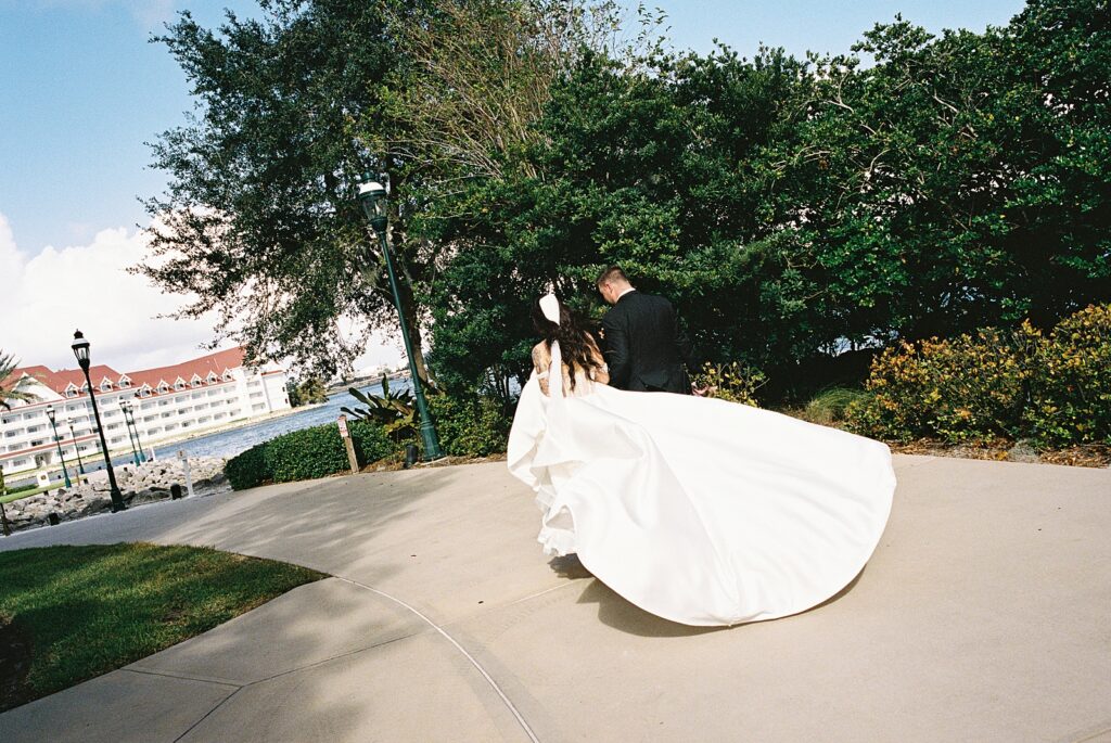 Bride and groom on their way to cocktail hour at Disneys Grand Floridian, captured by Walt Disney World wedding photographer Casie Marie Photography