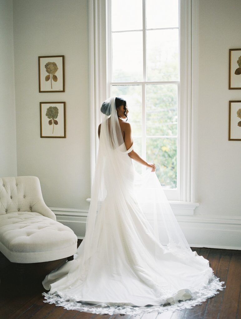 bride with mermaid gown and long veil inside the Merrimon-Wynne house wedding photographed by Casie Marie Photography